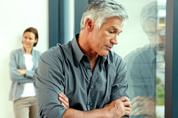0 Portrait of unhappy man with his his wife standing in the background